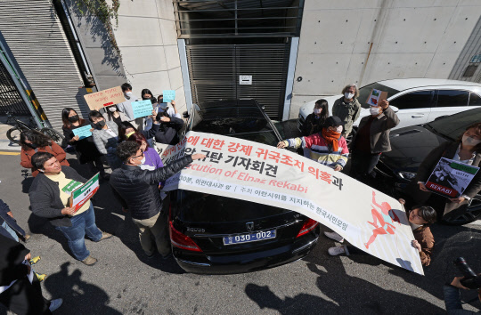 19일 서울 용산구 주한 이란이슬람공화국 대사관 앞에서 열린 레카비 선수 강제 귀국 조치 의혹 관련 이란 정부 규탄 기자회견에서 대사관 차량이 집회 장소를 막자 참가자들이 이에 항의하고 있다. 스포츠클라이밍 이란 대표 선수인 레카비는 한국에서 열린 2022 국제스포츠클라이밍연맹 아시아선수권대회에 히잡을 착용하지 않고 출전한 뒤 연락이 끊겨 실종 의혹에 휩싸였으나 지난 18일 본인의 인스타그램 계정을 통해 귀국 소식이 알려졌다. [연합뉴스]